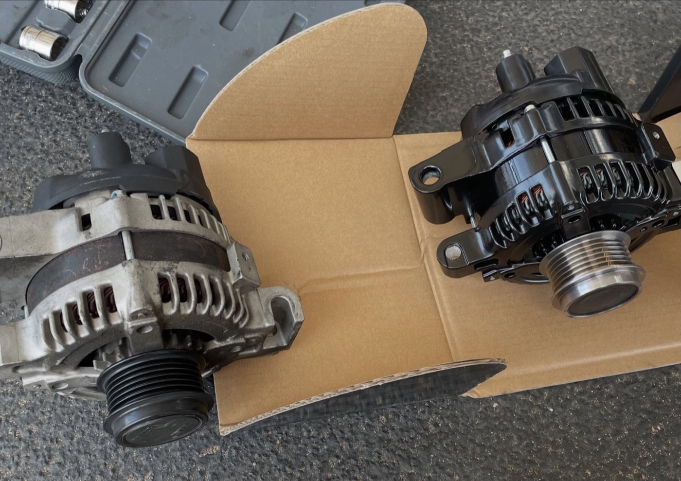 Old and new alternator during a mobile replacement